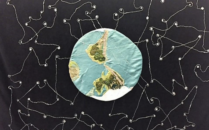 Fabric art - vision of URI’s network of groups each shining their own light and lighting up one another. Art by Louise Todd Cope, 2000.